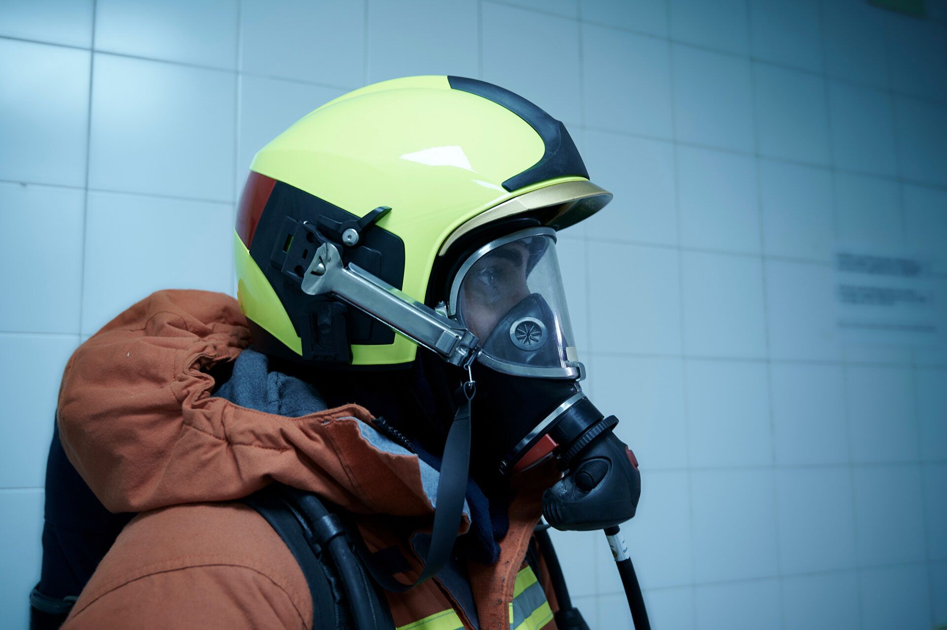 A person wearing a yellow helmet and a respiratory mask, showcasing breathing apparatus and respiratory protective equipment in a safety context.